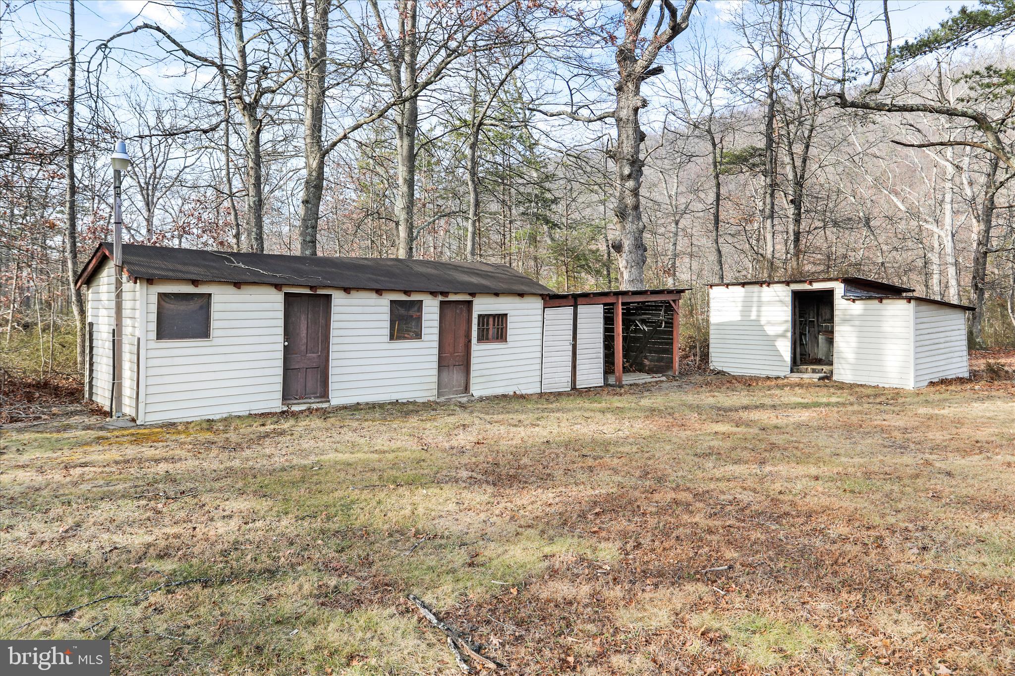 146 Miracle Drive Springfield, WV 26763 - Photo 31 of 40 a backyard of a house with large trees and brick wall