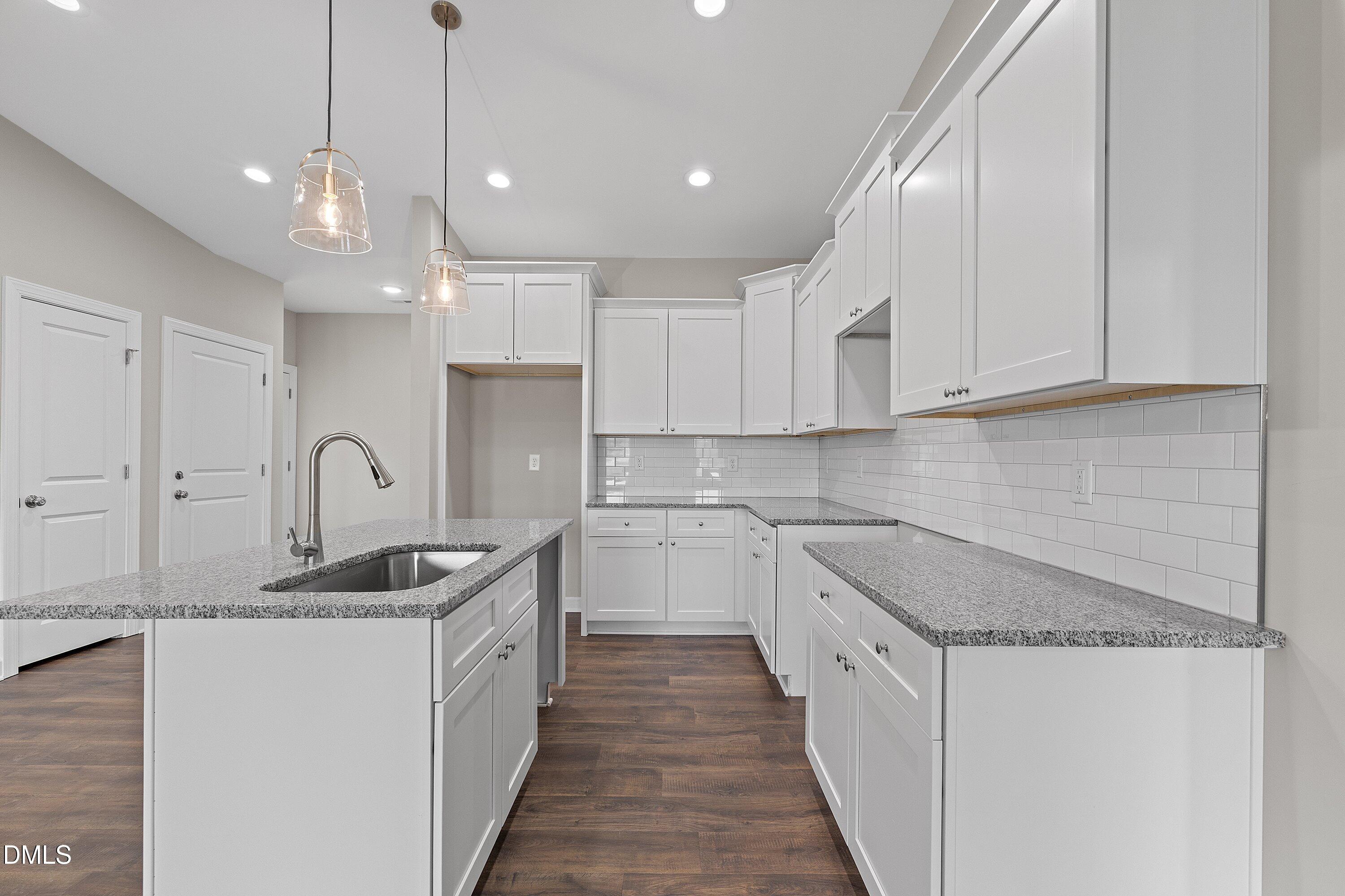 1117 Nor-Am Road Pikeville, NC 27863 - Photo 11 of 34 a kitchen with granite countertop a sink and white cabinets