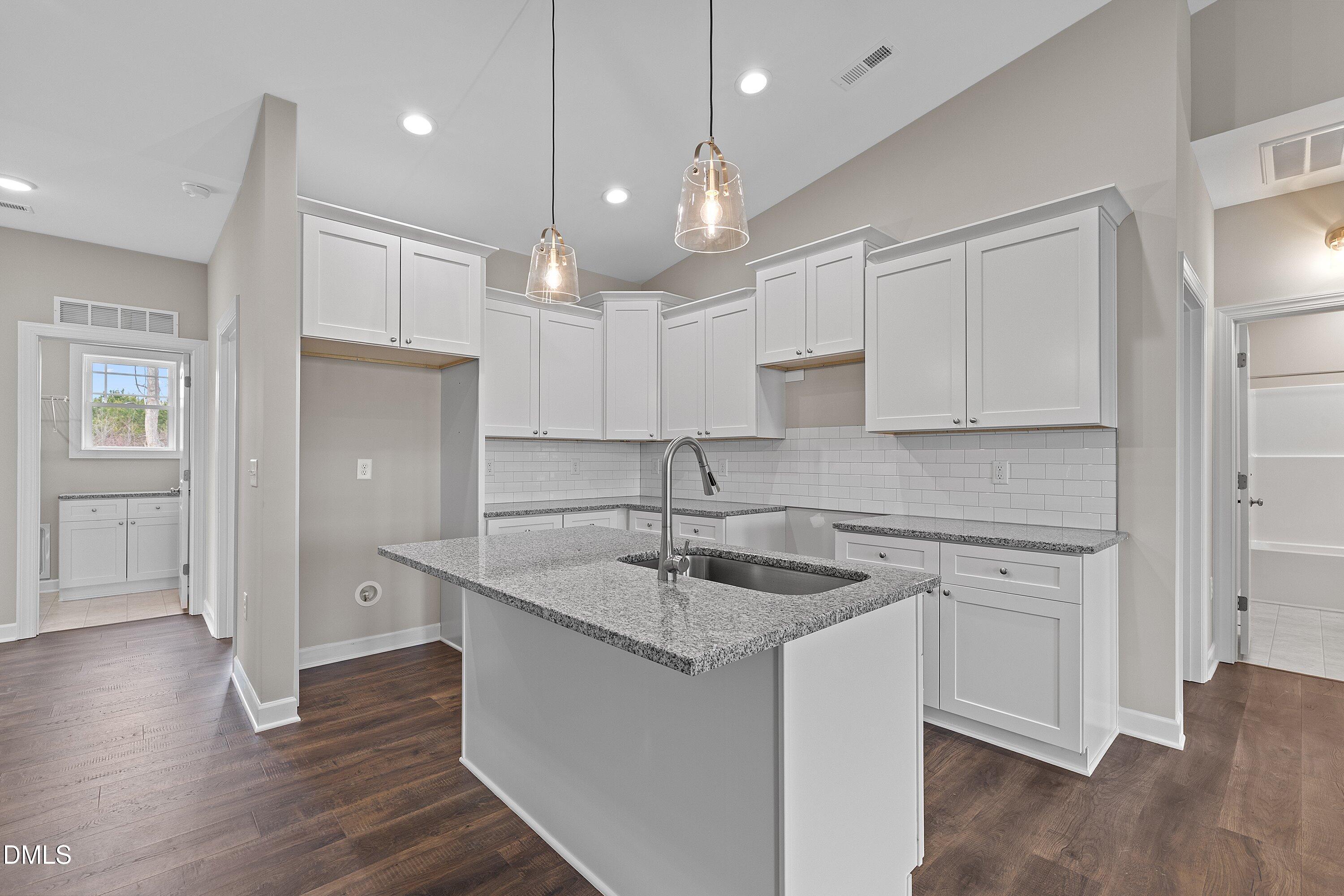 1117 Nor-Am Road Pikeville, NC 27863 - Photo 12 of 34 a kitchen with a sink chandelier and wooden floors