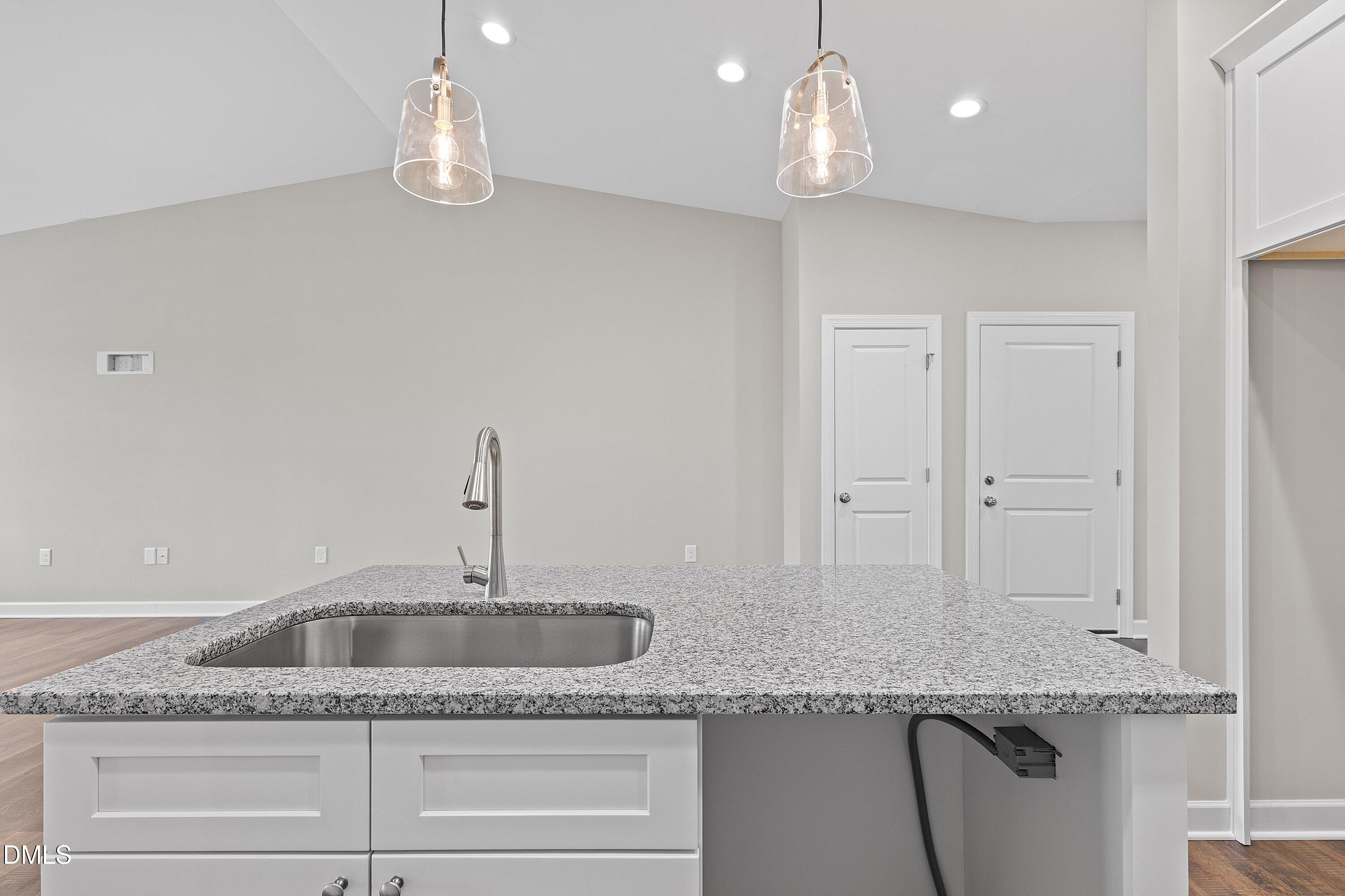 1117 Nor-Am Road Pikeville, NC 27863 - Photo 14 of 34 a kitchen with granite countertop a sink and chandelier