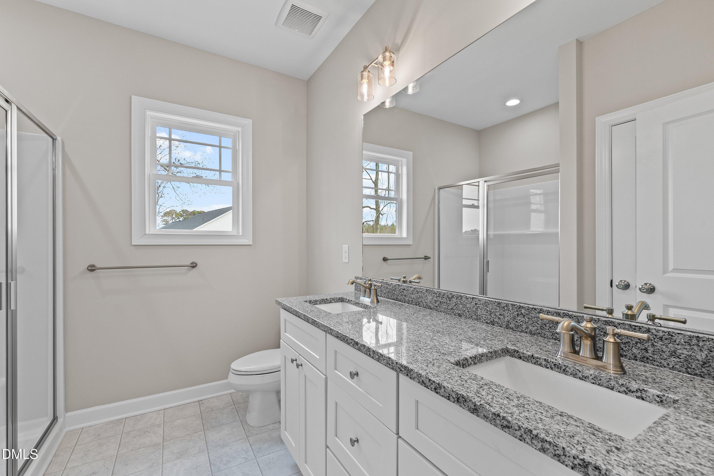 1117 Nor-Am Road Pikeville, NC 27863 - Photo 26 of 34 a bathroom with a granite countertop double vanity sink a mirror and a toilet