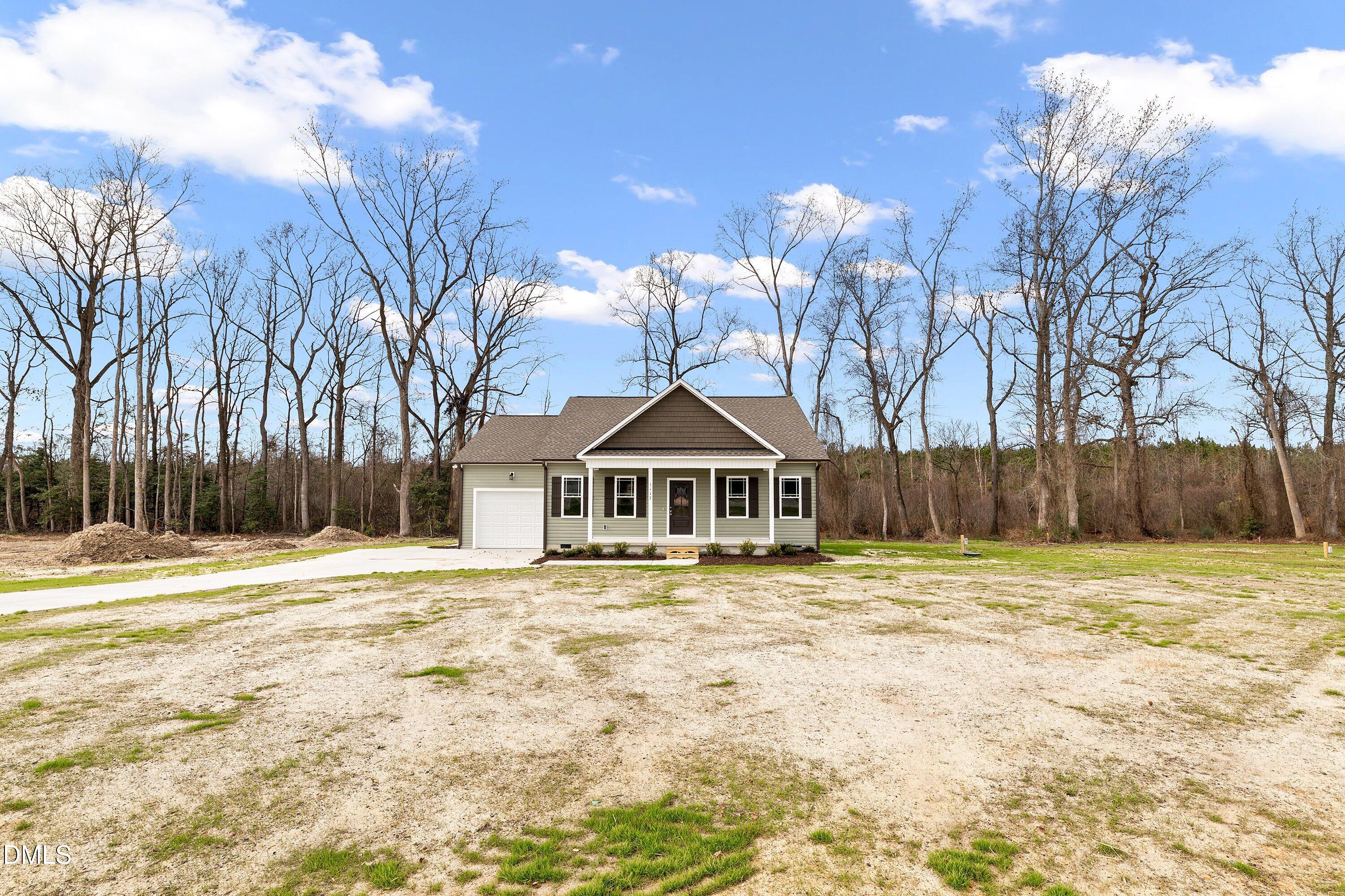 1117 Nor-Am Road Pikeville, NC 27863 - Photo 5 of 34 a front view of a house with a yard and trees