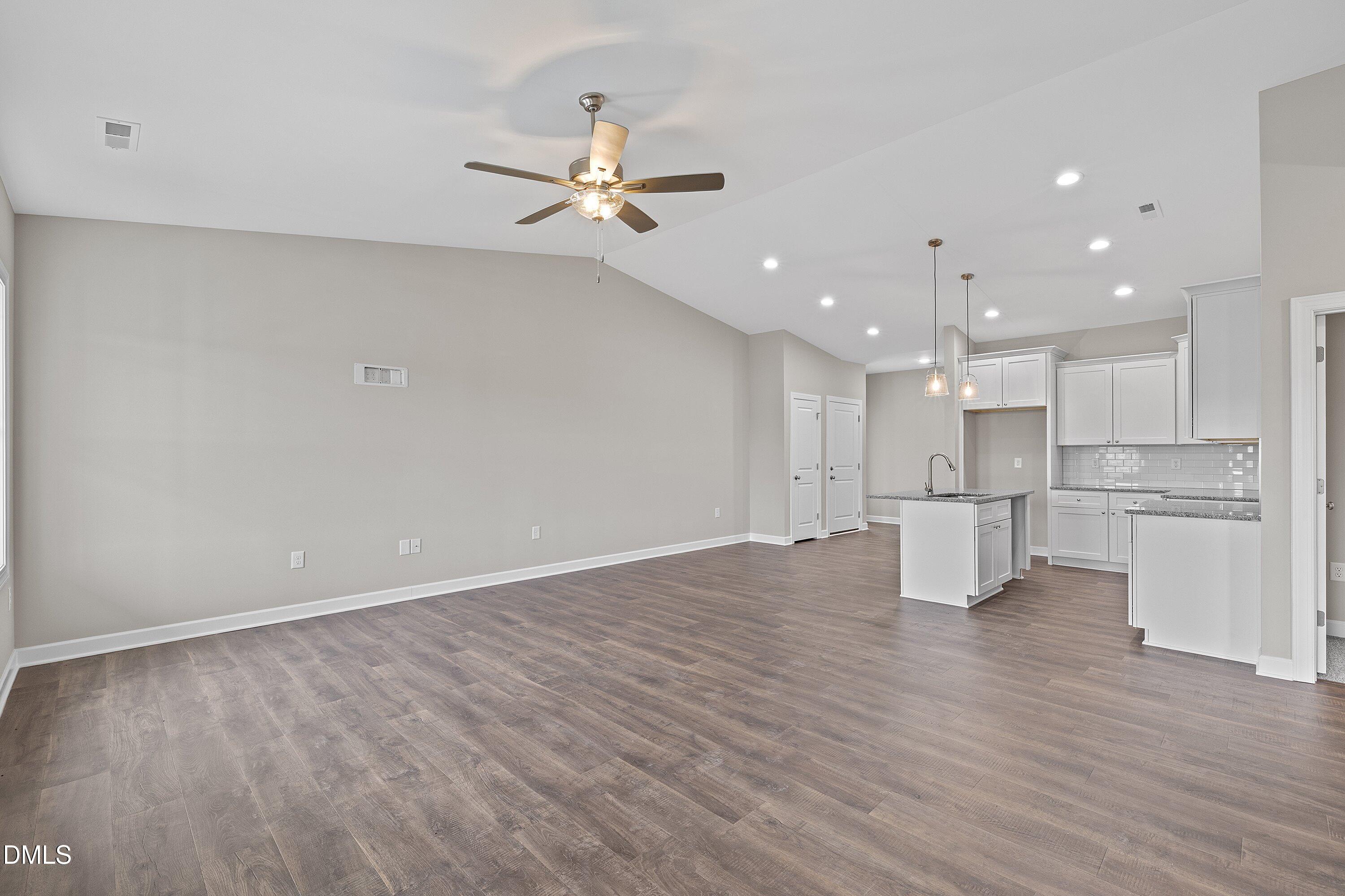 1117 Nor-Am Road Pikeville, NC 27863 - Photo 7 of 34 a view of an empty room with kitchen appliances and a ceiling fan