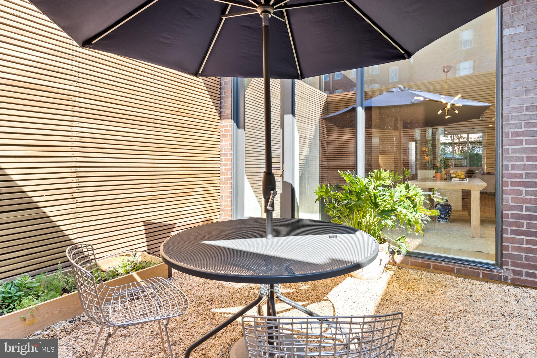 1202 T Street Northwest, Unit 1 Washington, DC 20009 - Photo 12 of 23 a view of a patio with a table and chairs under an umbrella