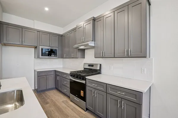a kitchen with stainless steel appliances granite countertop a sink stove and refrigerator
