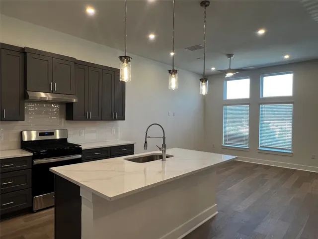 a kitchen with a sink a counter space appliances and cabinets
