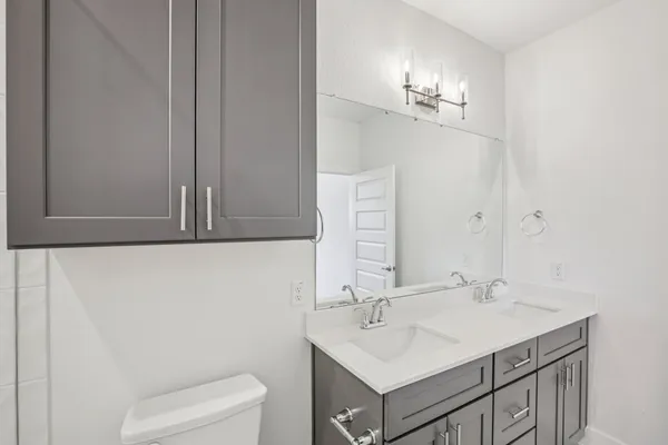 a bathroom with a sink a toilet and a mirror