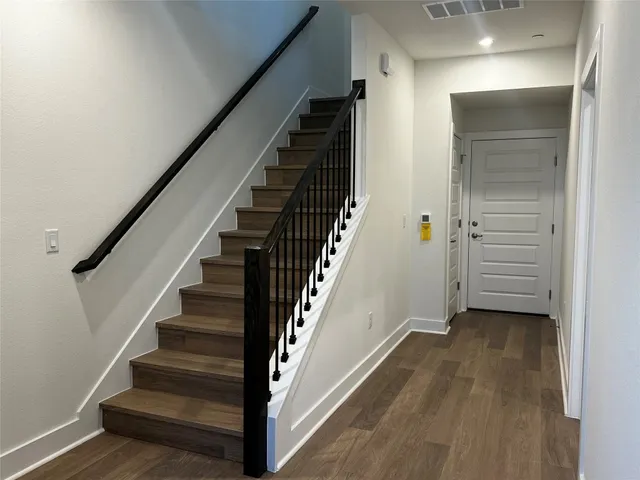a view of a hallway with wooden floor and entryway
