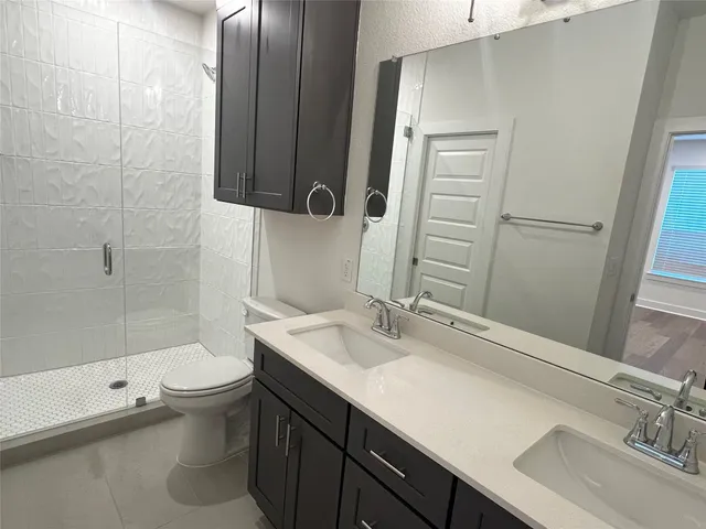 a bathroom with a sink a toilet and shower