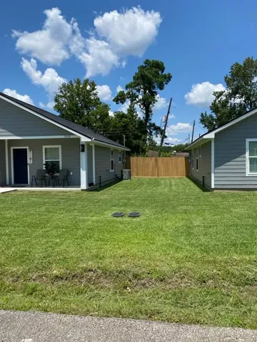a front view of house with yard and trees in the background