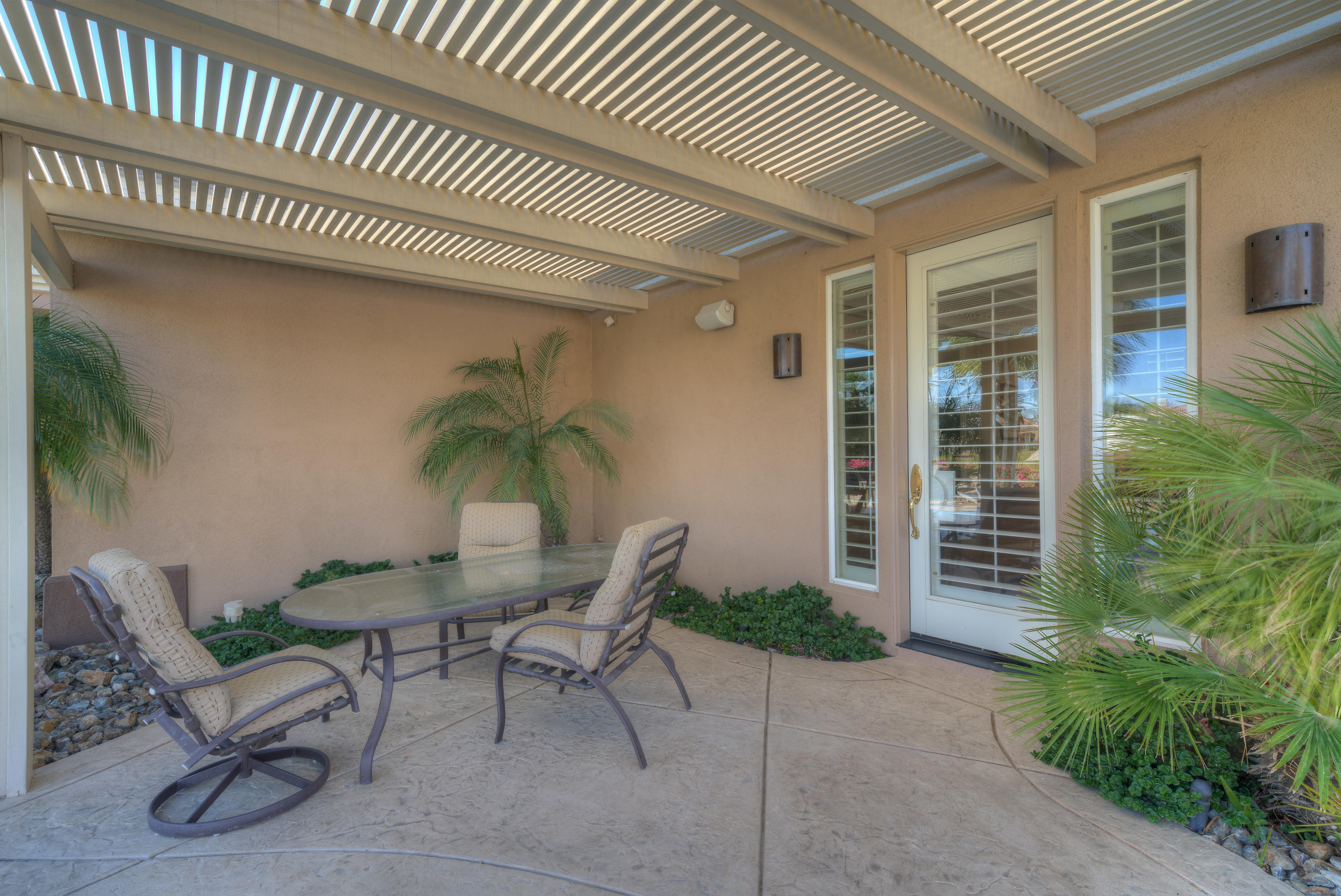 4 Vía Verde Rancho Mirage, CA 92270 - Photo 52 of 63 a patio with a table and chairs and potted plants