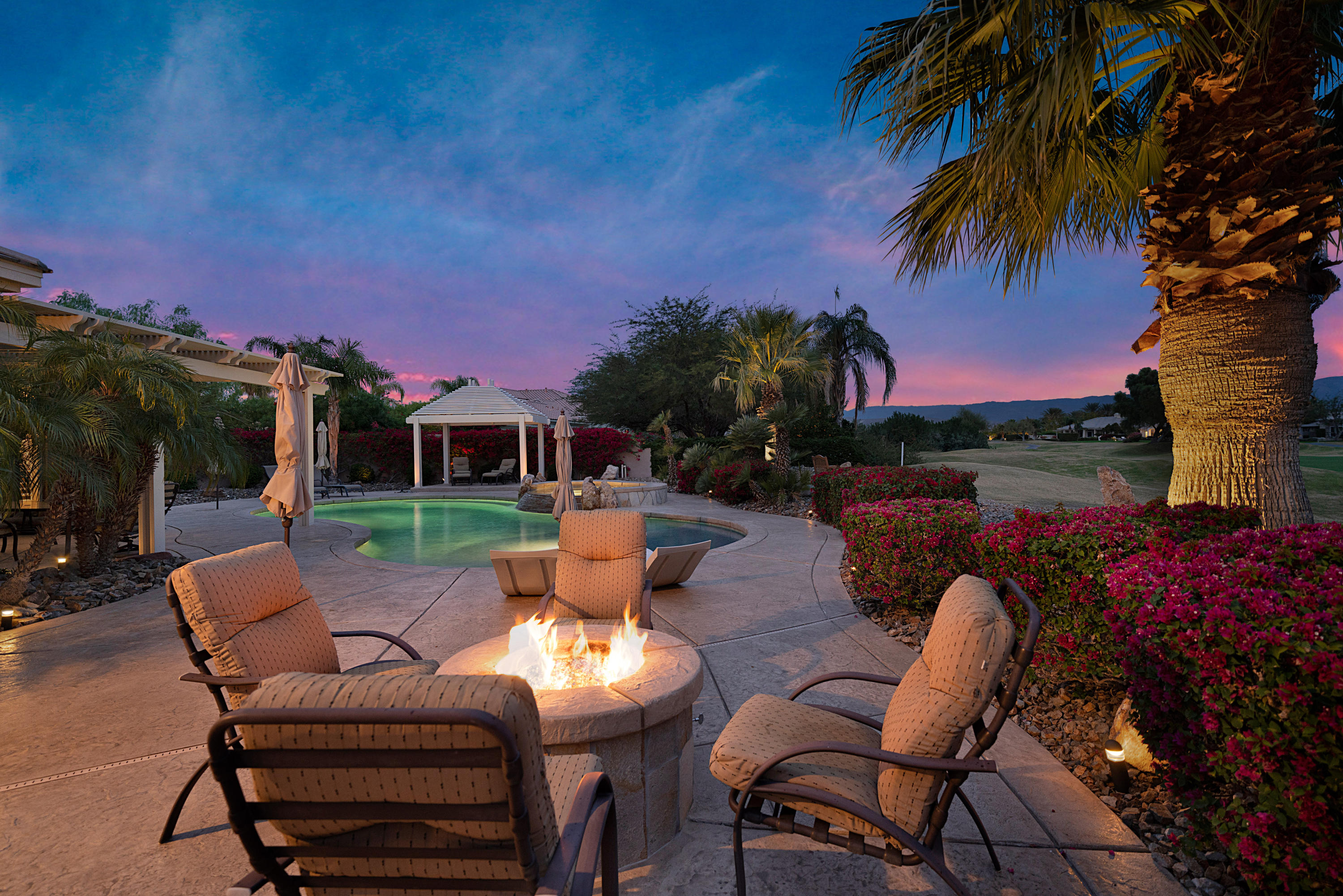 4 Vía Verde Rancho Mirage, CA 92270 - Photo 57 of 63 a patio with tables and chairs pool and a fire pit