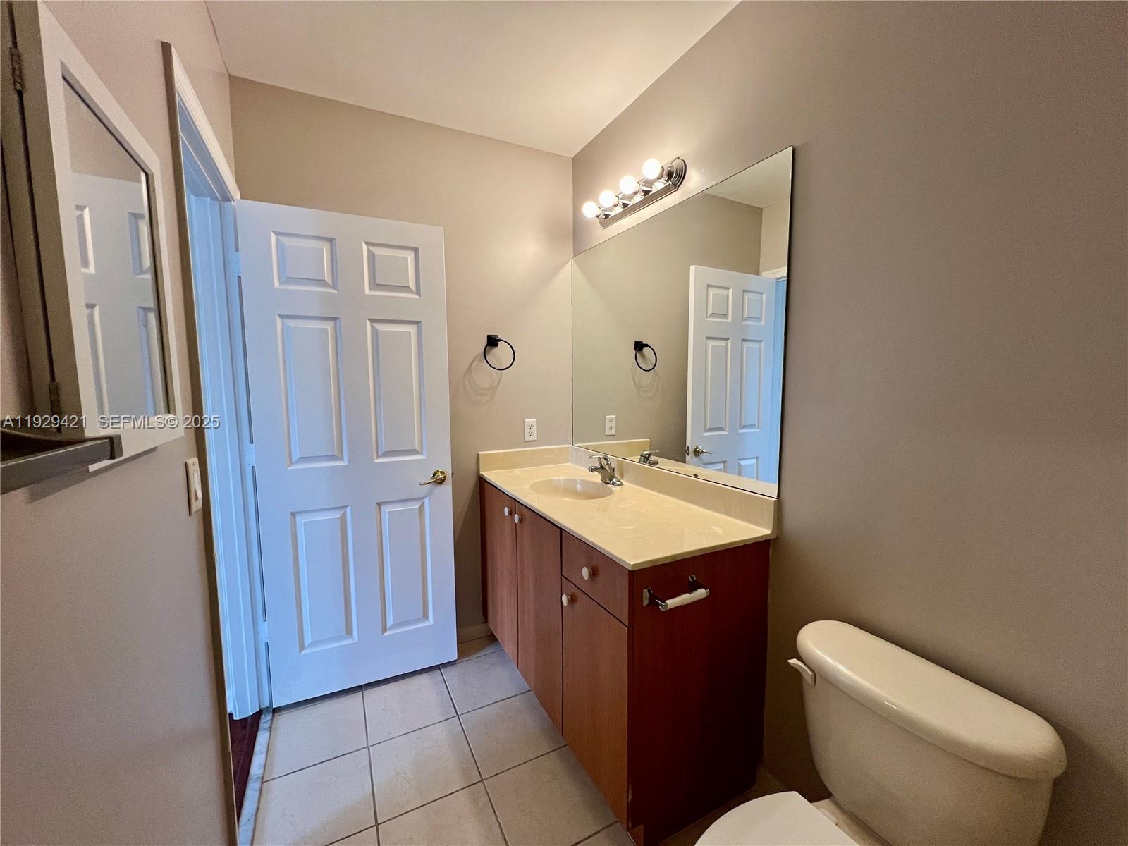 8208 Southwest 29th Street, Unit 101 Miramar, FL 33025 - Photo 11 of 19 a bathroom with a toilet sink and mirror