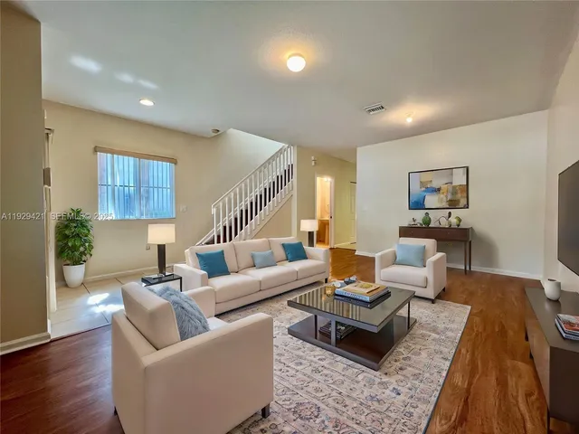 a living room with furniture and wooden floor