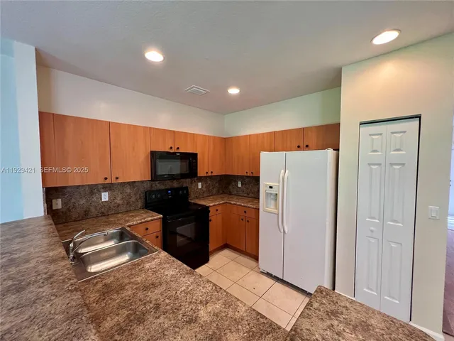 a kitchen with stainless steel appliances granite countertop a refrigerator and a stove