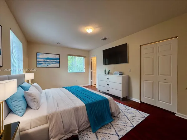 a bedroom with a bed and a flat screen tv