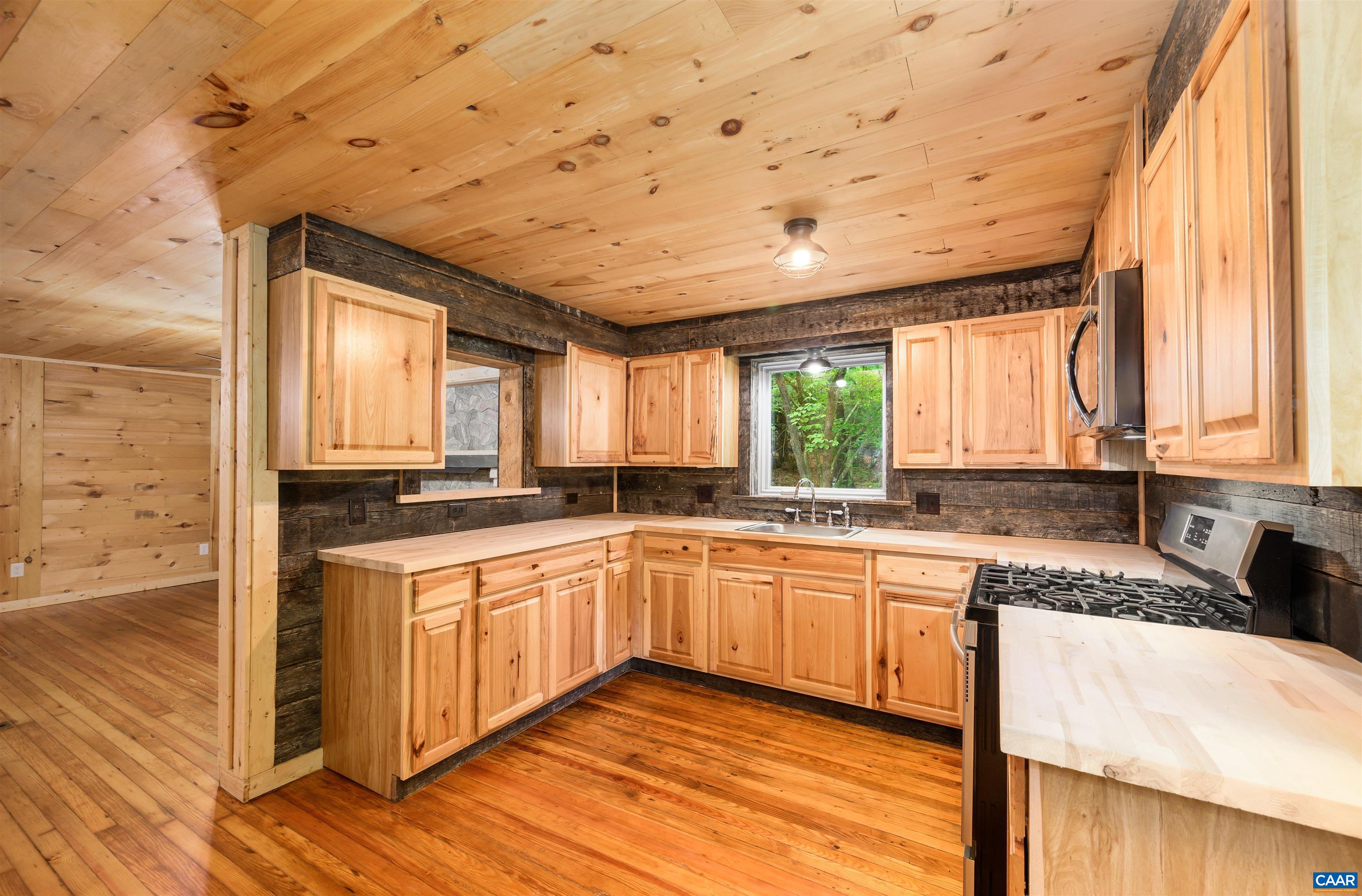 3882 Firehouse Road Howardsville, VA 24562 - Photo 10 of 75 a large kitchen with a large window and wooden cabinets