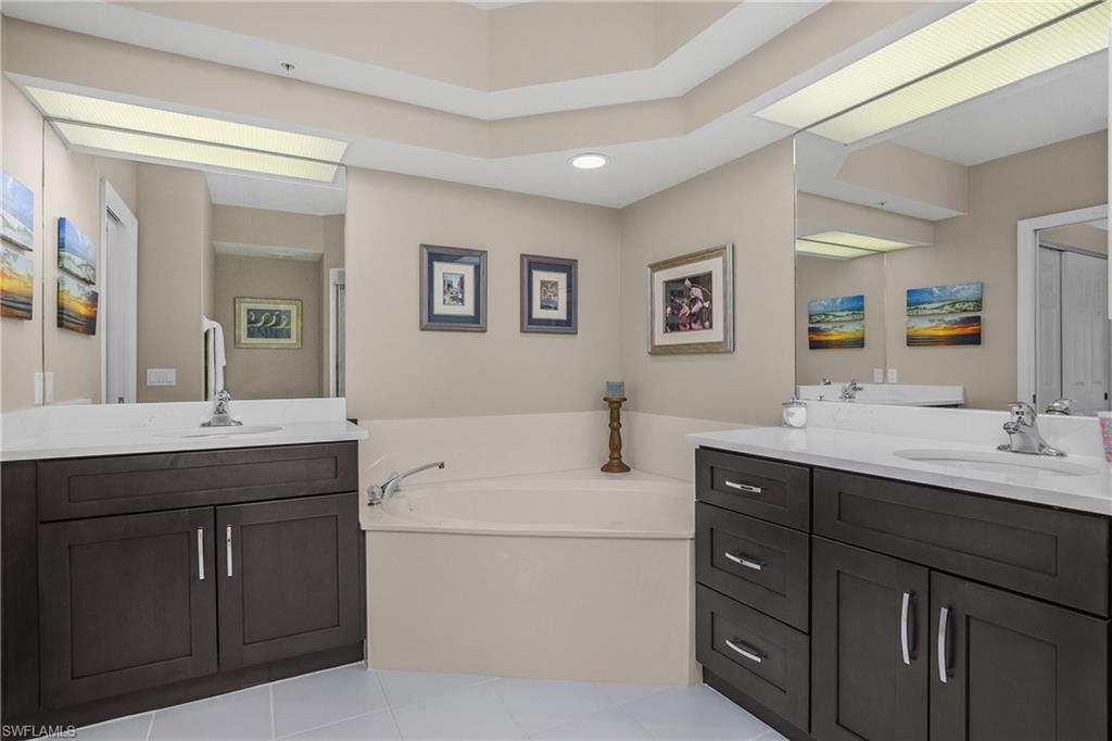 6838 Lantana Bridge Road, Unit 103 Naples, FL 34109 - Photo 21 of 41 a en suite bathroom with a double vanity sink and a mirror