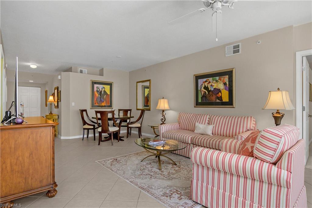 6838 Lantana Bridge Road, Unit 103 Naples, FL 34109 - Photo 10 of 41 a living room with furniture and a chandelier