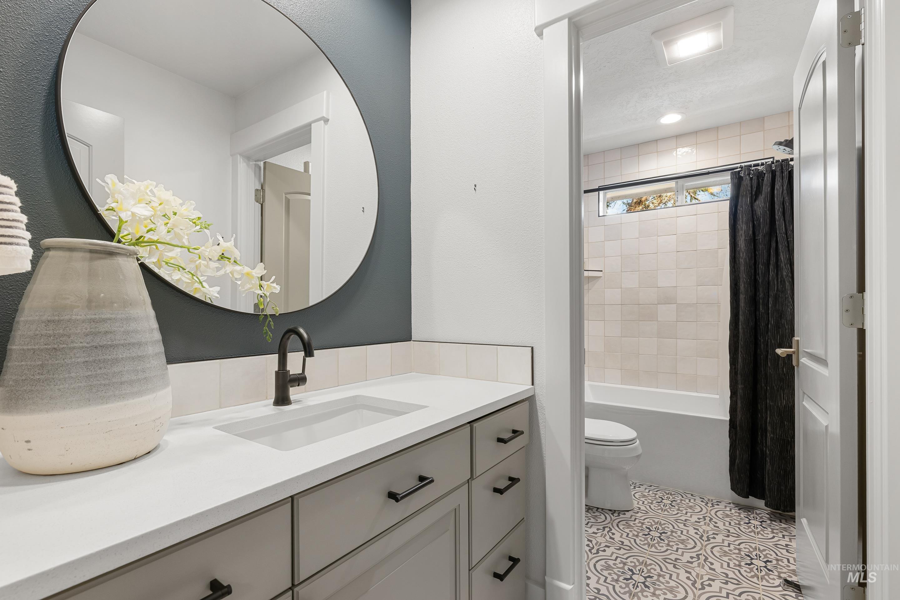 1166 East Rivers End Drive Eagle, ID 83616 - Photo 32 of 50 Full bathroom featuring vanity, shower / bathtub combination with curtain, light tile patterned floors, and a textured ceiling