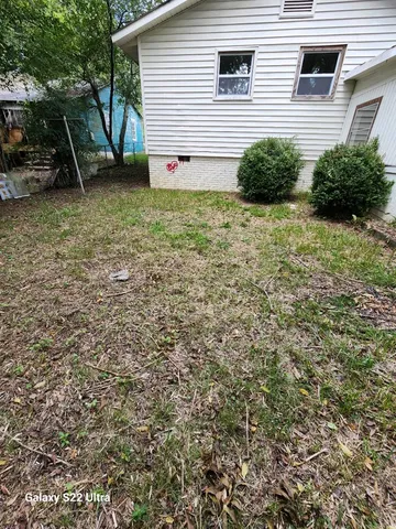 a view of backyard with plants and a wooden fence