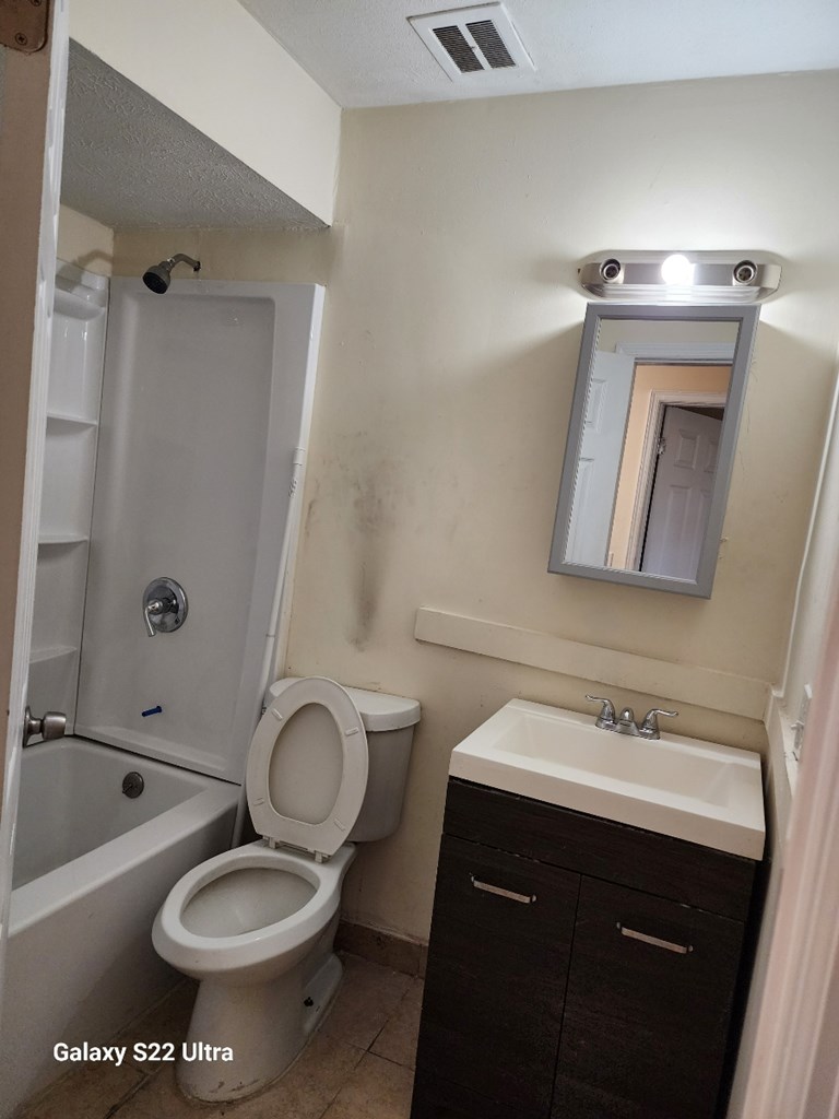 5118 11th Avenue Columbus, GA 31904 - Photo 2 of 12 a bathroom with a sink toilet a mirror and shower