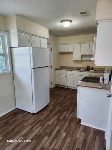 a kitchen with a refrigerator and a stove top oven