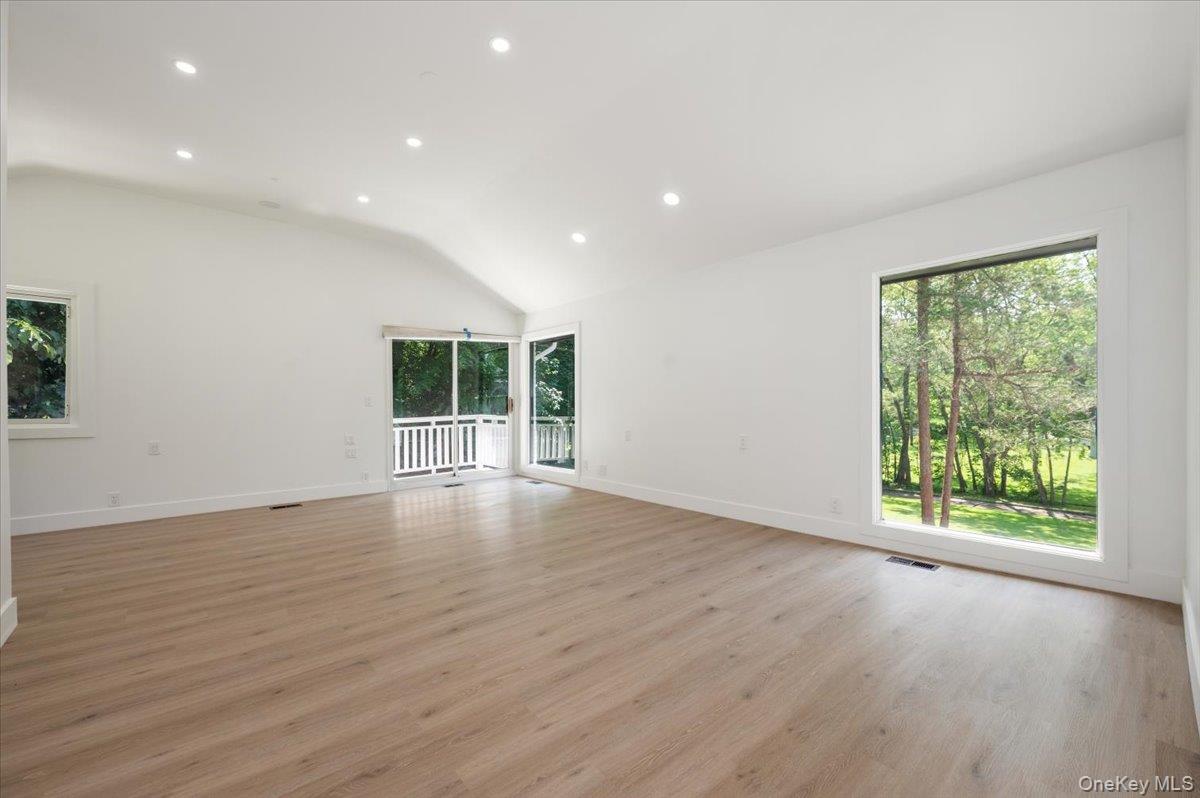 452 East Shore Road Great Neck, NY 11024 - Photo 13 of 35 an empty room with wooden floor and windows