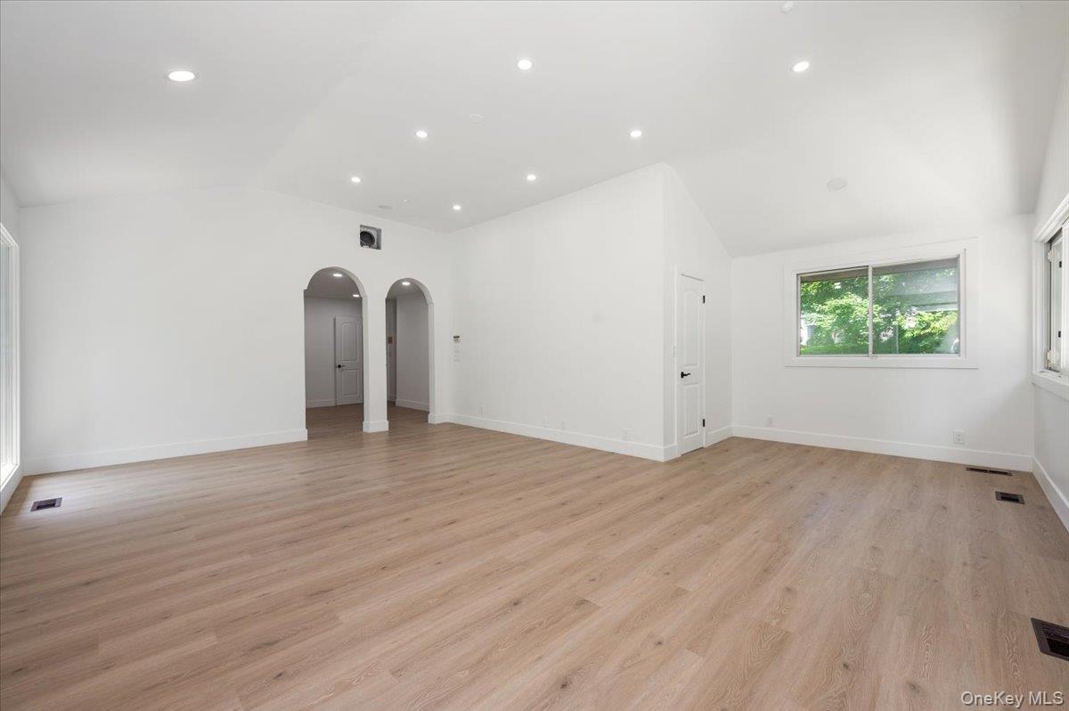 452 East Shore Road Great Neck, NY 11024 - Photo 14 of 35 an empty room with wooden floor and windows