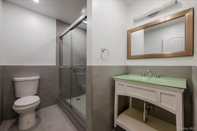 a bathroom with a toilet a sink and mirror
