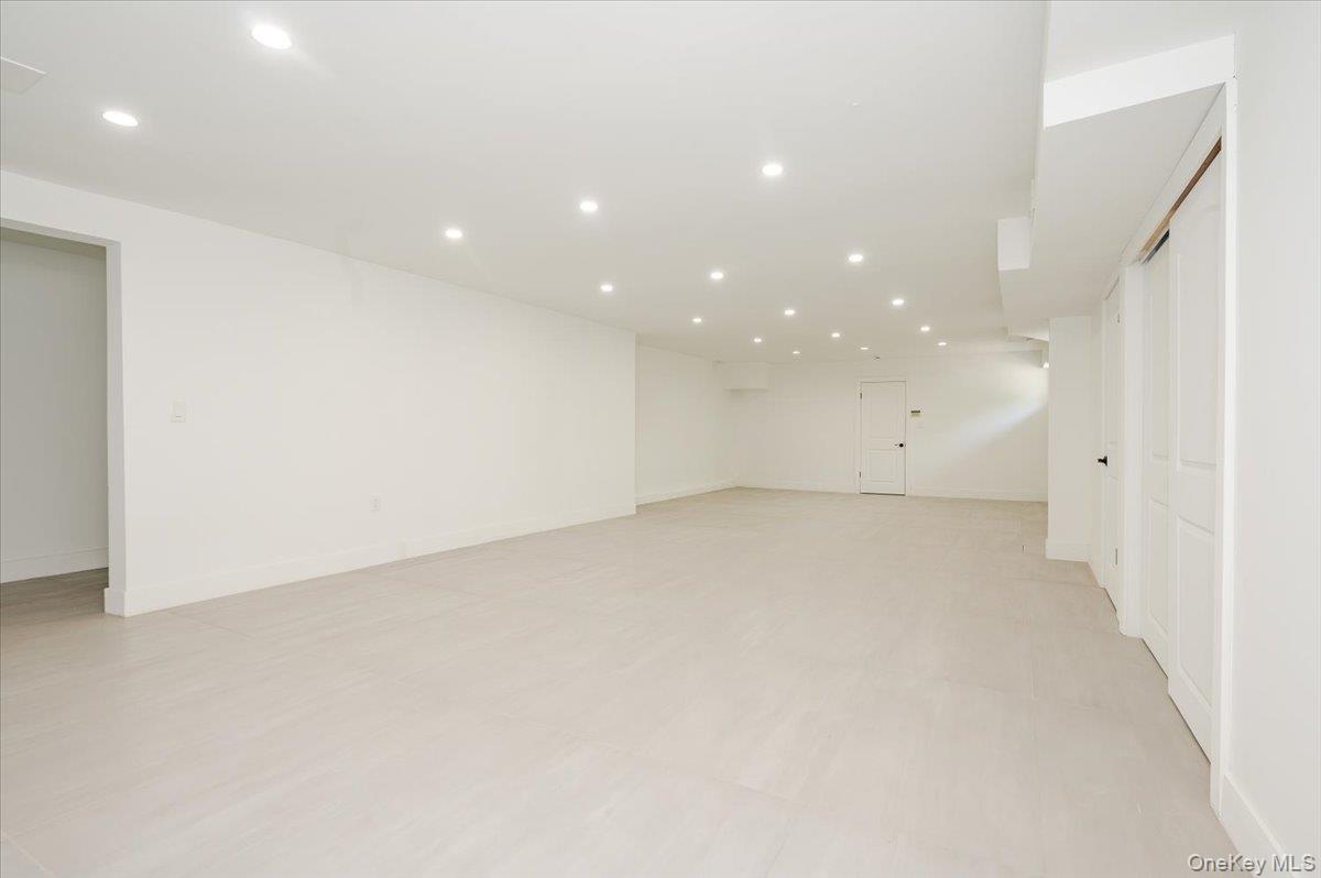 452 East Shore Road Great Neck, NY 11024 - Photo 24 of 35 an empty room with a white wall & cabinetry