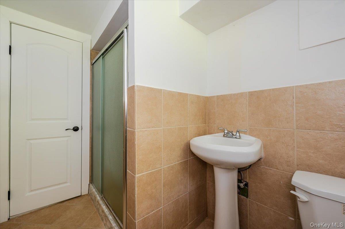 452 East Shore Road Great Neck, NY 11024 - Photo 25 of 35 a bathroom with a sink toilet and a mirror