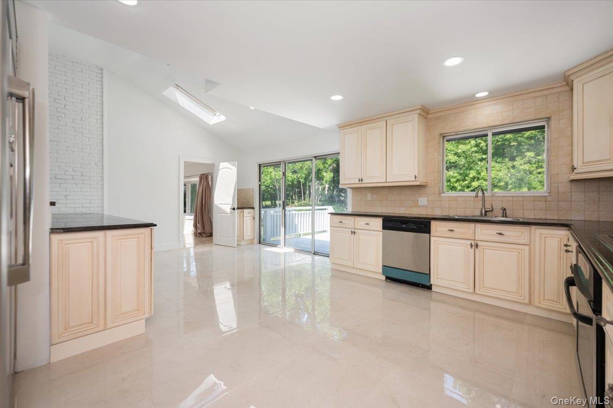 452 East Shore Road Great Neck, NY 11024 - Photo 10 of 35 a kitchen with white cabinets and white appliances
