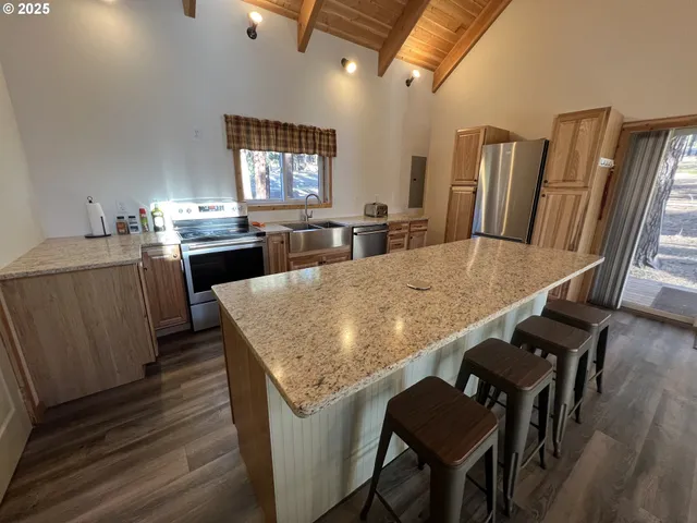 a kitchen with stainless steel appliances granite countertop table chairs and wooden floor
