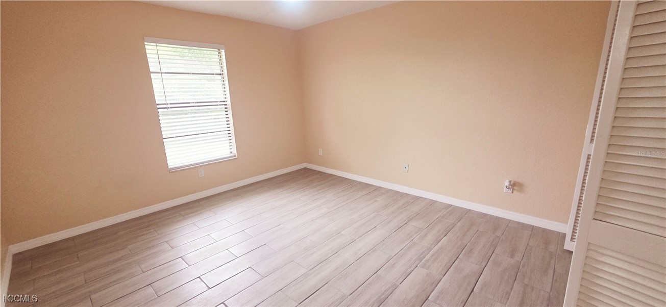 930 Southwest 34th Street Cape Coral, FL 33914 - Photo 29 of 31 an empty room with wooden floor and windows