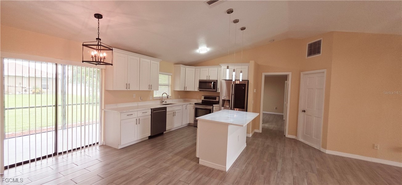 930 Southwest 34th Street Cape Coral, FL 33914 - Photo 31 of 31 a kitchen with sink a refrigerator and wooden floor