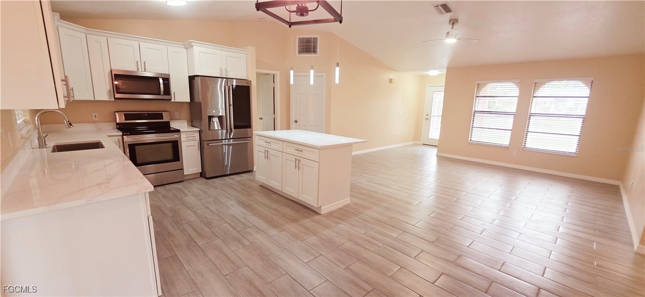 930 Southwest 34th Street Cape Coral, FL 33914 - Photo 6 of 31 a kitchen with a stove a refrigerator and a sink