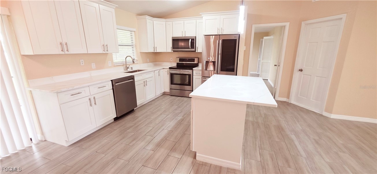 930 Southwest 34th Street Cape Coral, FL 33914 - Photo 7 of 31 a kitchen with stainless steel appliances a refrigerator stove top oven and cabinets