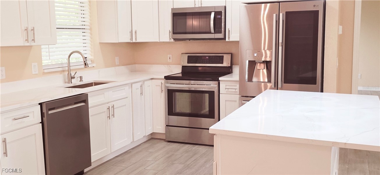 930 Southwest 34th Street Cape Coral, FL 33914 - Photo 8 of 31 a kitchen with granite countertop a sink stove and refrigerator