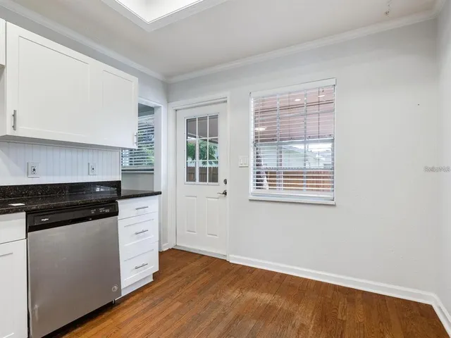 a kitchen with granite countertop white cabinets and appliances