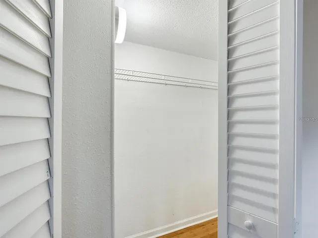 a view of walk in closet with empty racks
