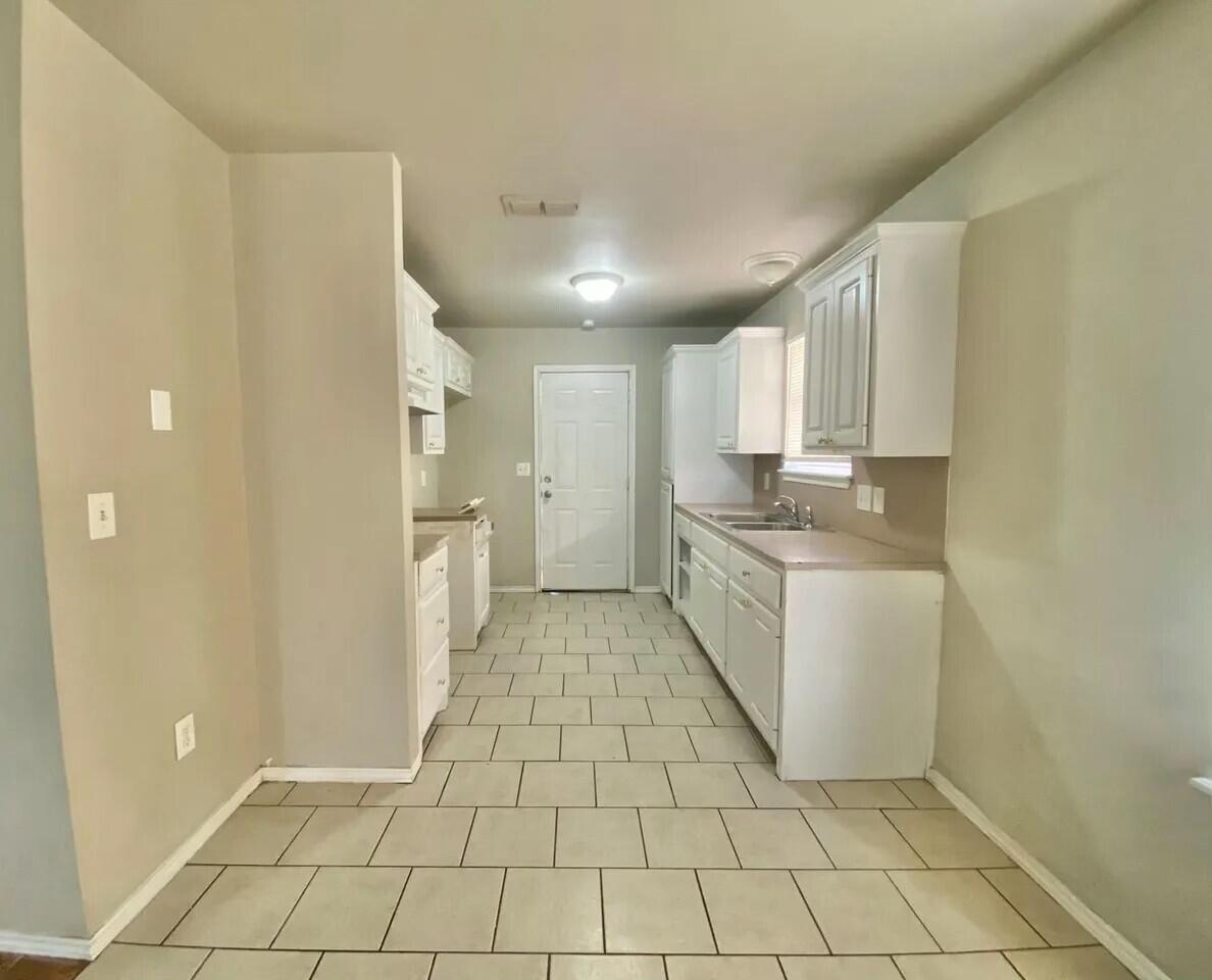 Package Package Property Lubbock, TX 79415 - Photo 24 of 33 a kitchen with a sink a refrigerator and cabinets