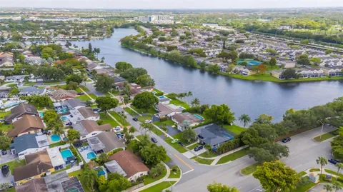an aerial view of residential houses with outdoor space and lake view