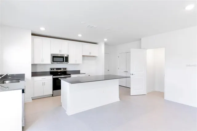 a kitchen with white cabinets and stainless steel appliances