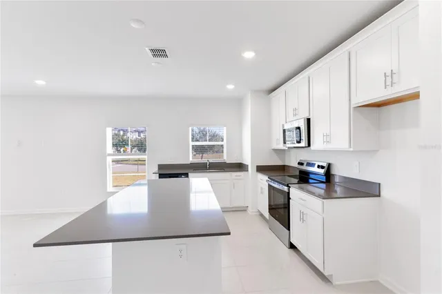 a kitchen with stainless steel appliances granite countertop a sink stove and a window