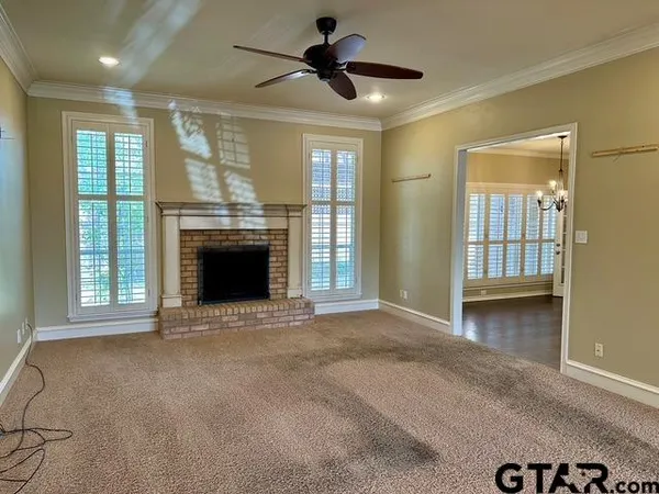 a view of an empty room with a fireplace and a window