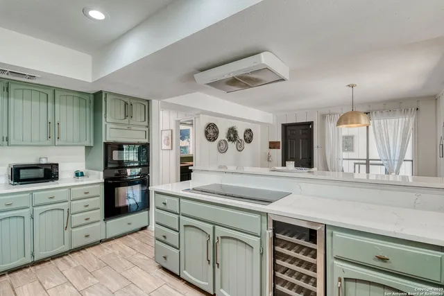 a kitchen with kitchen island granite countertop a sink and cabinets