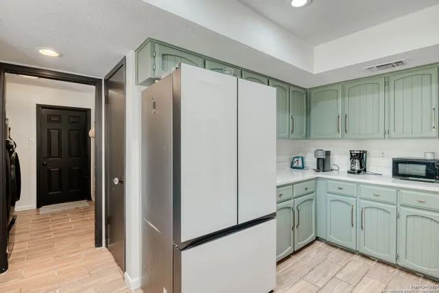 a kitchen with a refrigerator sink and cabinets