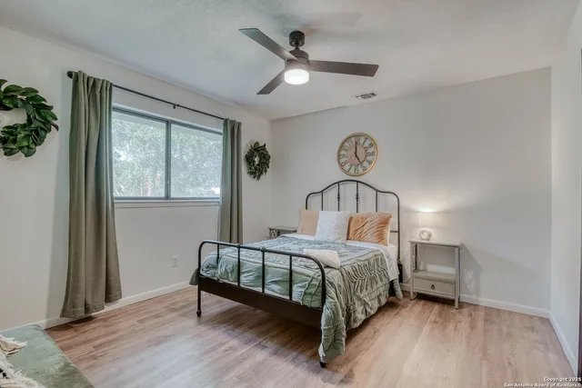 a bedroom with a bed next to a window with a chandelier