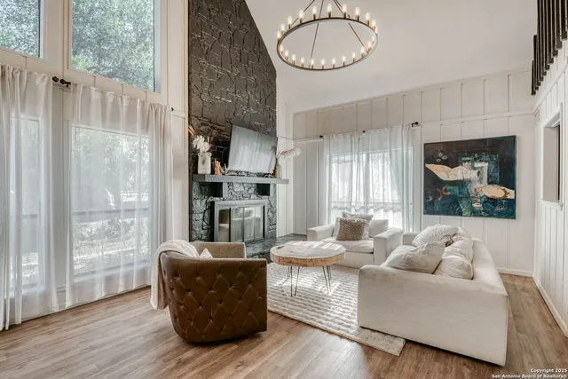a living room with furniture a fireplace and a floor to ceiling window